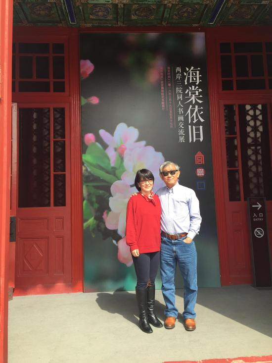 刘梅琴与丈夫王祥龄在展览海报前
