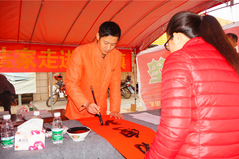 广东省书协会员、茂名市书画院副院长、茂名市书协秘书长杨中介为群众写春联